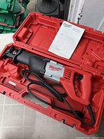 Open case showing saw, cord, and manual