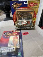 Front view of both sealed Winner's Circle Dale Earnhardt die-cast car packages showing Sam Bass Collection and packaging details