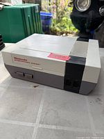 Front and side view of Nintendo Entertainment System console showing logo, ports, and overall wear