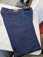 Full view of folded jeans showing front and leg length