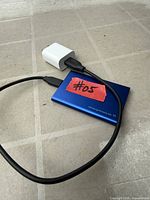 Blue Samsung Portable SSD T7 connected to USB-C cable and white USB-C wall charger