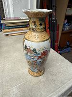 Full view of vase front showing painted landscape and gilt patterns