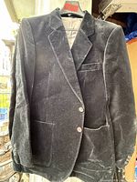 Front view of black velvet jacket on hanger showing lapel, buttons, and pockets