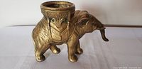 Left-side view of gold-tone spelter elephant incense burner showing howdah bowl and surface patina