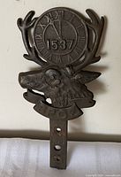 Front view showing elk head, clock face, banner, stake
