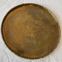 Full view of circular brass tray showing engravings and rim