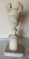 Front view showing urn, pedestal and marble plinth