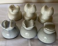 Front view showing all six insulators: three white rear row, two gray and one sky blue front row
