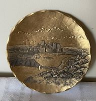 Front view of bronze plate showcasing raised relief Pittsburgh skyline and bridges