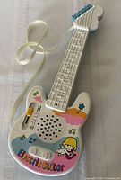 Front view showing graphics, controls, speaker, strap