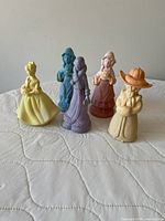 Front view of five pastel figural lady perfume bottles