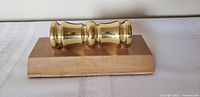 Front view of brass cannon barrel card holder on wood base