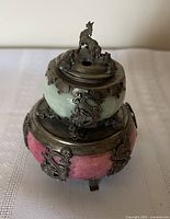 Front angle showing celadon upper tier, pink lower tier, metal dragon and horse finial