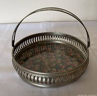 Overall view of silver-plated round basket with swing handle and floral insert