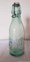 Full view of green glass bottle with swing-top