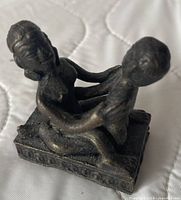 Front left view of bronze Kama Sutra figurine on plinth