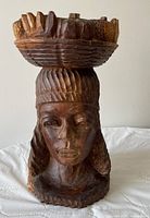 Full view of bust showing female head and fruit basket