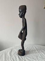 Left profile of entire sculpture showing carved cap, drum, base