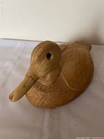 Front side view of carved wood duck decoy showing head, bill, eye and feather detailing