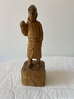 Front view of carved wood figure on base