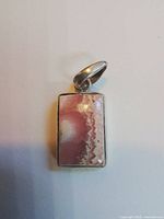 Front view of pendant showing banded rhodochrosite cabochon set in silver bezel