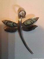 Front view of sterling silver dragonfly pendant showing abalone inlay wings and bail