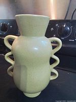 Full view of vase showing triple-loop handles and overall form