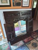 Front view with shutters open showing mirror and carving