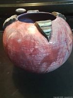 Front side of plum-magenta marbled stoneware vessel with teal rim tab visible