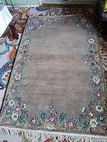 Full view showing entire rug, field, floral border and fringe