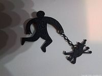 Full brooch showing human figure and dog connected by chain
