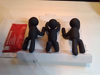 Three Umbra Buddy wall hooks and sealed red hardware packet on packaging