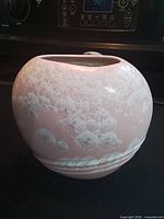 Front view of pink porcelain flat vase showing crystalline glaze and shape