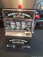 Front view showing Bars & 7s Wins! graphics, reels, payout tray and red dome light