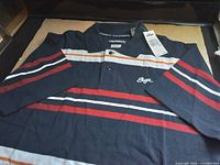 Full view of entire polo shirt showing stripes, collar, and tag