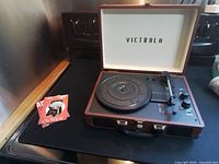 Victrola suitcase turntable open on surface showing platter and exterior case