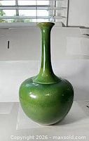 Full view of emerald green long-neck vase showing overall form