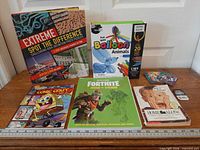 Group shot of all items including balloon animals kit, four books, SpongeBob comic book, Skylanders cards