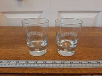 Front view of both Baileys tumblers showing etched logos and bubble bases with ruler for scale