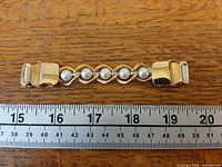 Full view of sweater clip beside ruler showing length