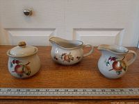 Full view of sugar bowl, gravy boat and creamer with ruler for scale