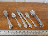 All flatware pieces laid out with ruler for scale