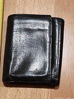 Closed black leather trifold wallet front view