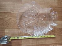 Top view of clear acrylic snowman tray with tape measure showing width