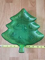 Front view of green glass Christmas tree platter with embossed motifs