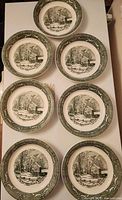 Seven matching plates laid out showing fronts