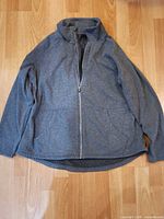 Front view of gray Skechers full-zip jacket laid flat