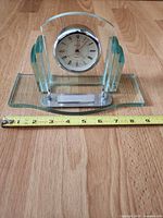 Front view of glass and metal Linden desk clock with tape measure showing width
