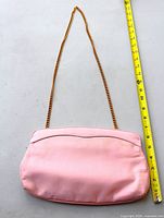 Front view of pink satin bag with full chain shown beside measuring tape indicating width ~11 in and chain drop ~18 in