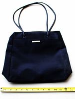 Front view of black Nine West tote showing exterior and straps with tape for width reference